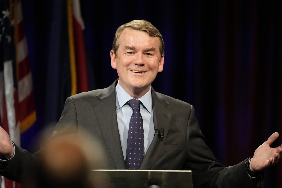 Michael Bennet stands at a podium