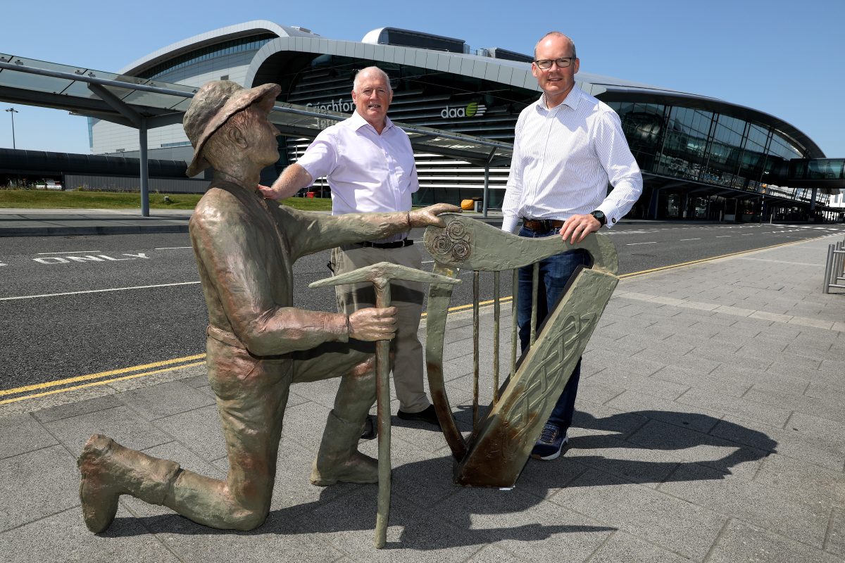 Two men pose with the statue