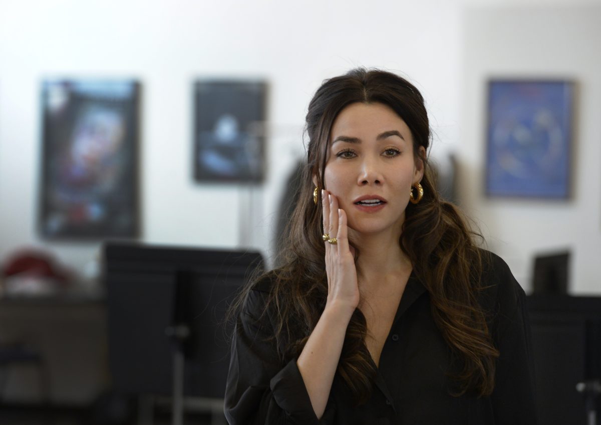 A woman holds a hand against her cheek.