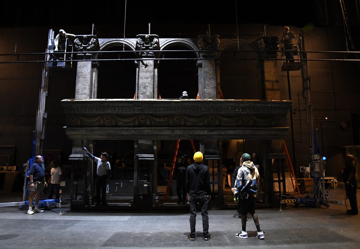 Crew members work to set up a wall. 