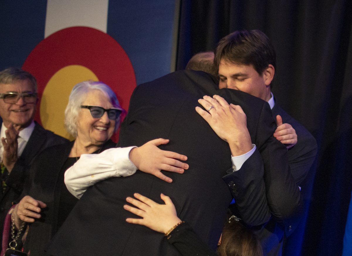 Jared Polis hugs his husband Marlon Reis